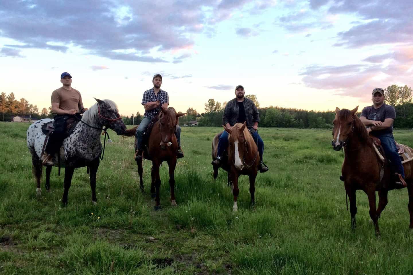 four men riding horses